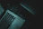 Close-up of a man using a laptop with dark mode enabled in a dimly lit study.