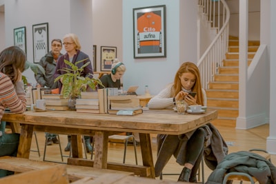 A diverse group of readers engaging with news on various devices in a cozy setting.