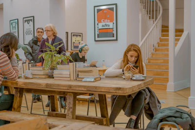 Listeners enjoying local music and cultural shows through their smartphones at a café.