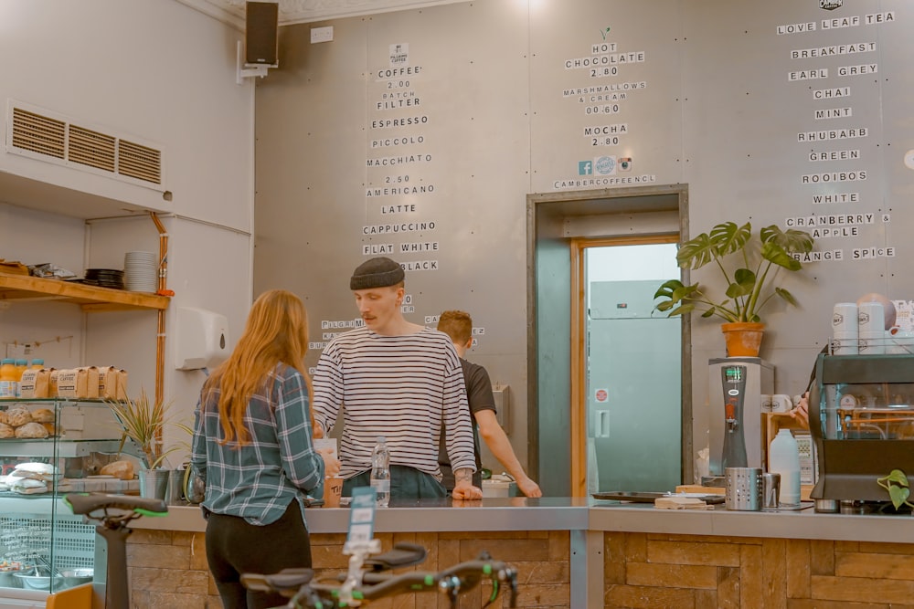 man and woman talking in front of gray tabletop inside shop