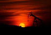 oil pump jack silhouette against red sunset