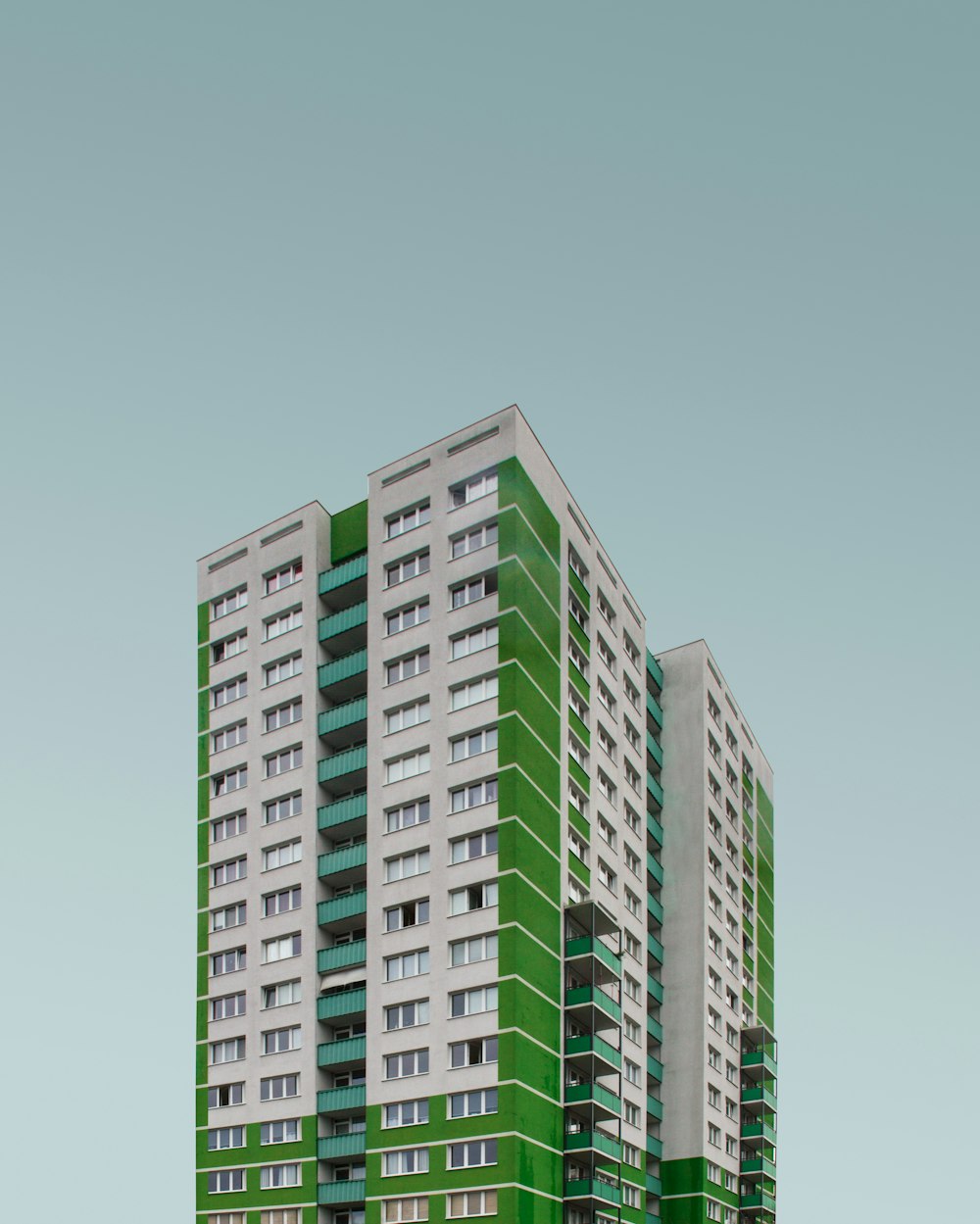 Grün-weißes Betonhochhaus tagsüber