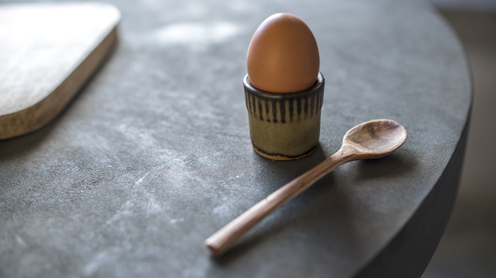 cuchara marrón al lado del huevo beige