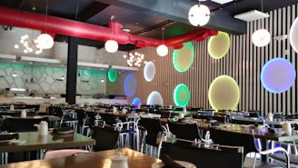 Chic corporate event dining area with sleek black and maroon theme and live food stations