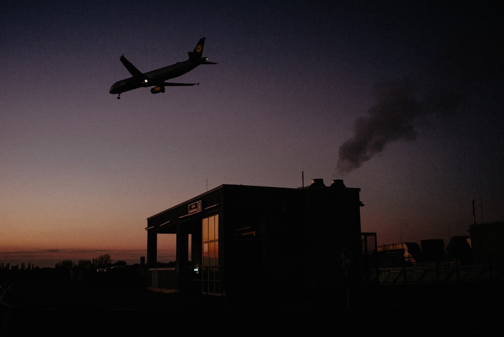 airplane flying over concrete building