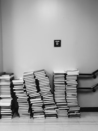 grayscale photography of pile of books