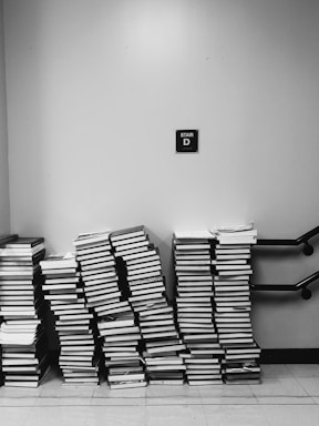 grayscale photography of pile of books