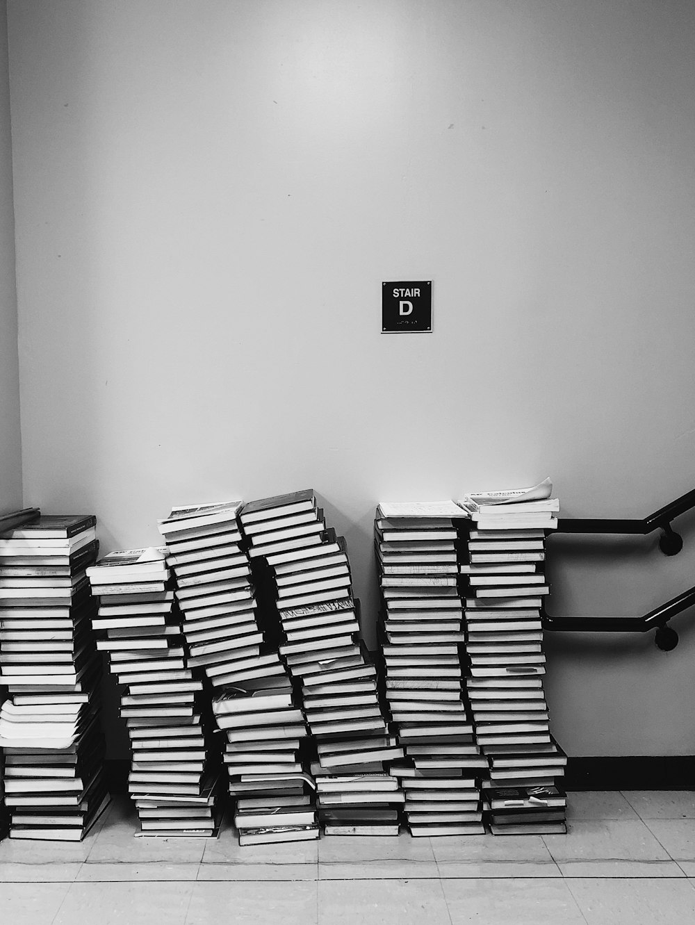 grayscale photography of pile of books