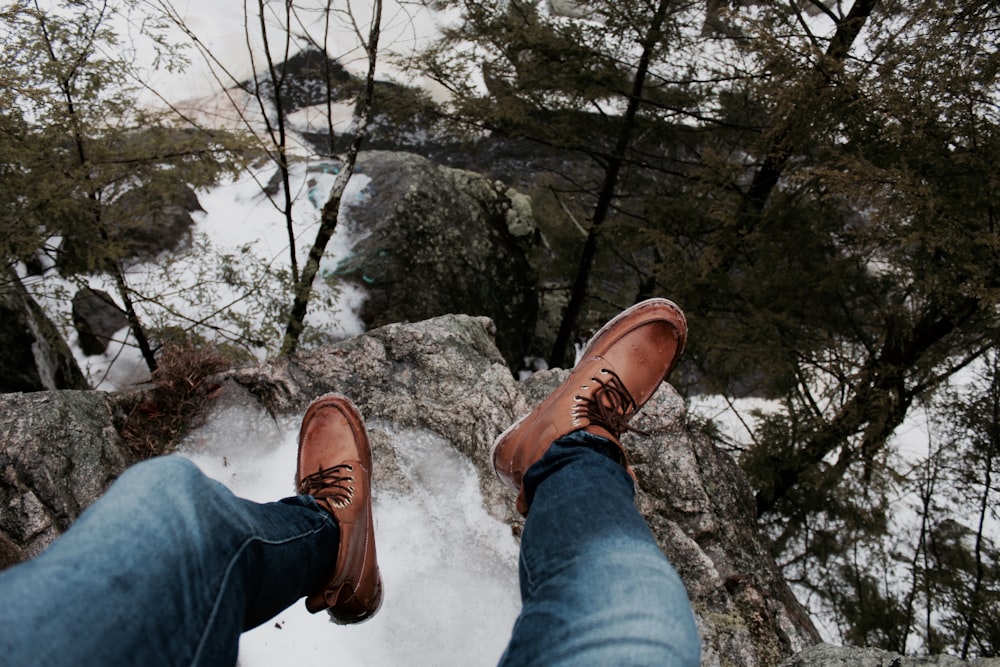 person sitting on the edge of the cliff