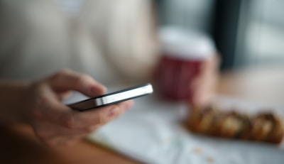 selective focus photography of person holding gray phone