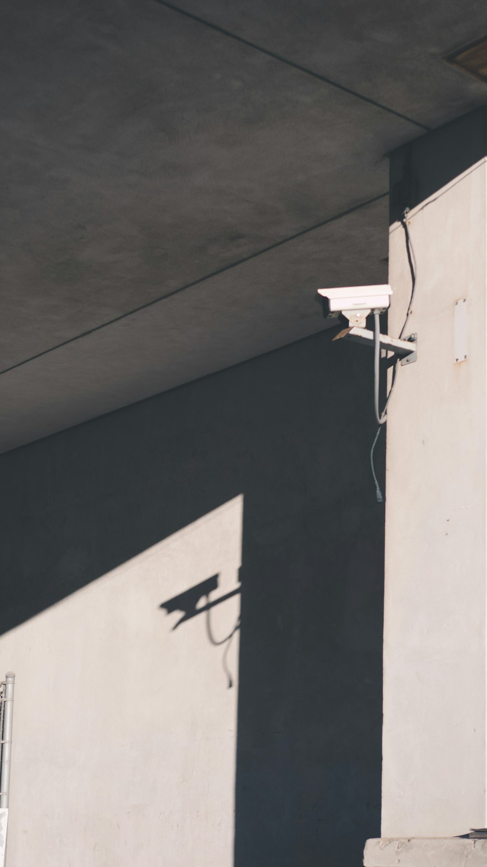 white box security camera on wall