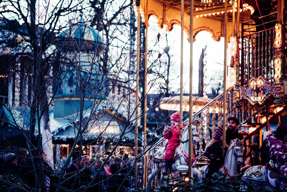 girl riding carousel taken at daytime