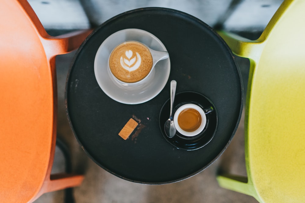 aerial photo of two cups of coffees on saucer