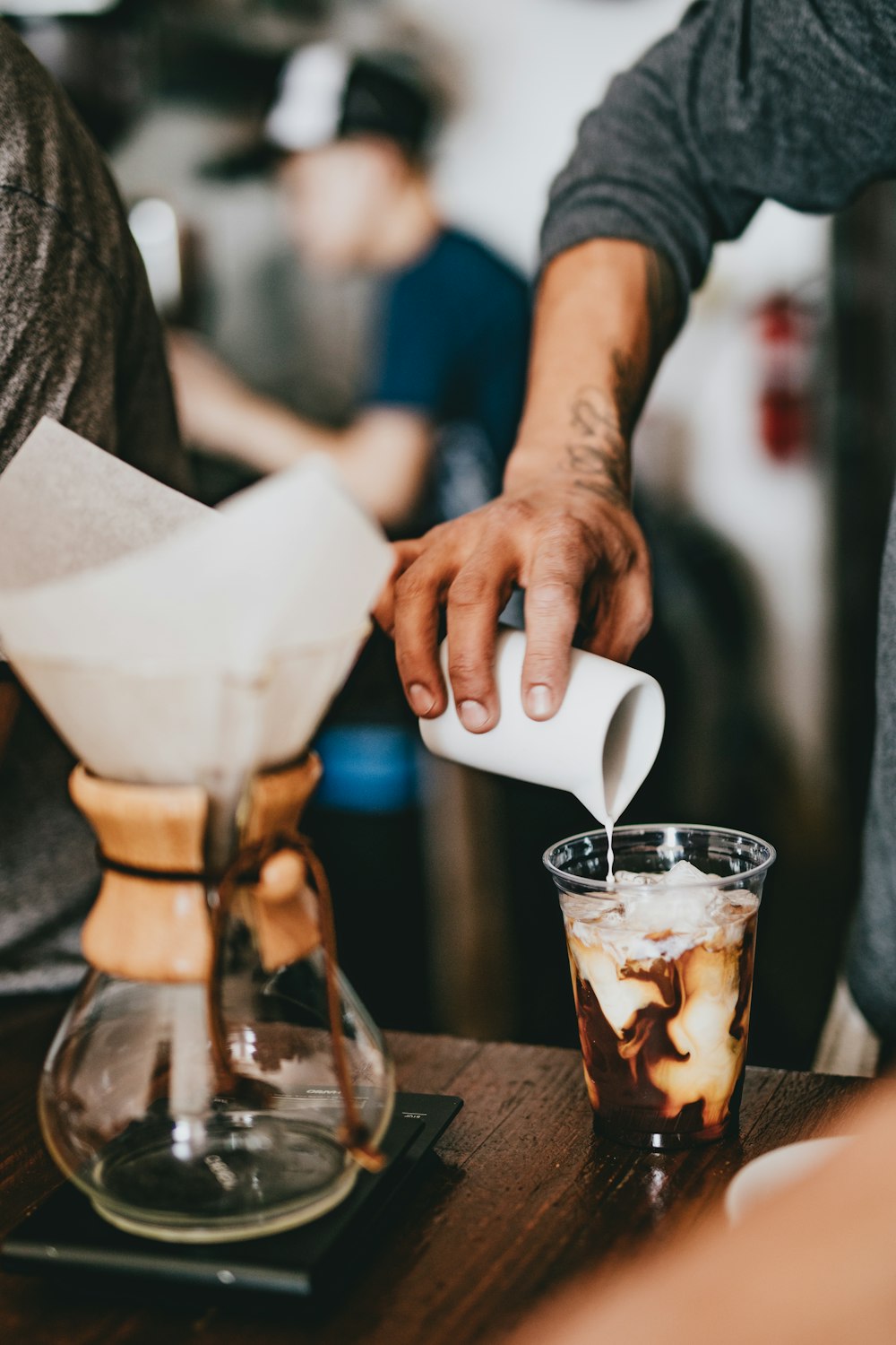 man pouring milk on cup