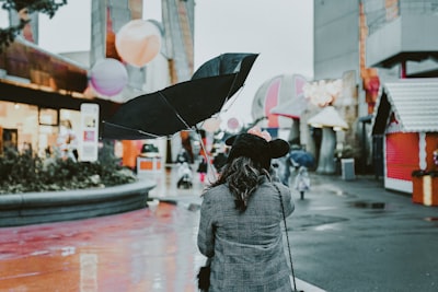 person holding black umbrella during daytime