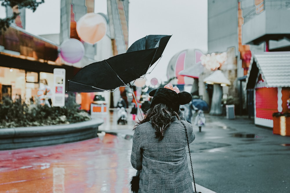 person holding black umbrella during daytime