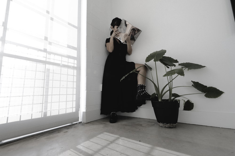 Frau im schwarzen Kleid liest Buch