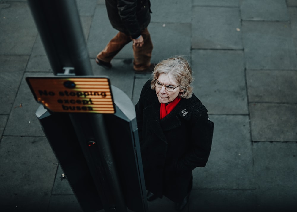 woman beside post near street