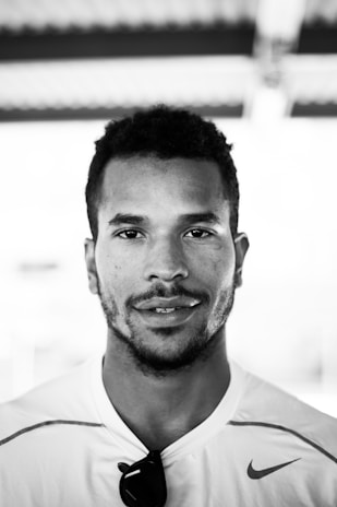 A striking portrait of Kevin, founder of Kwamo Exports, standing confidently against a backdrop of industrial glamour.