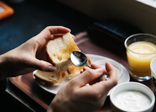 person spreading jam on bread