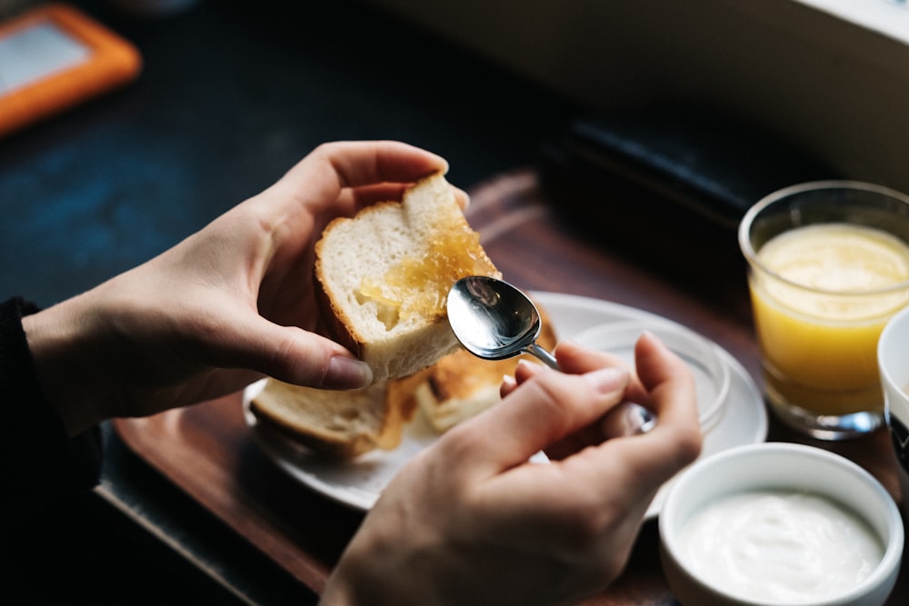 persona che spalma la marmellata sul pane