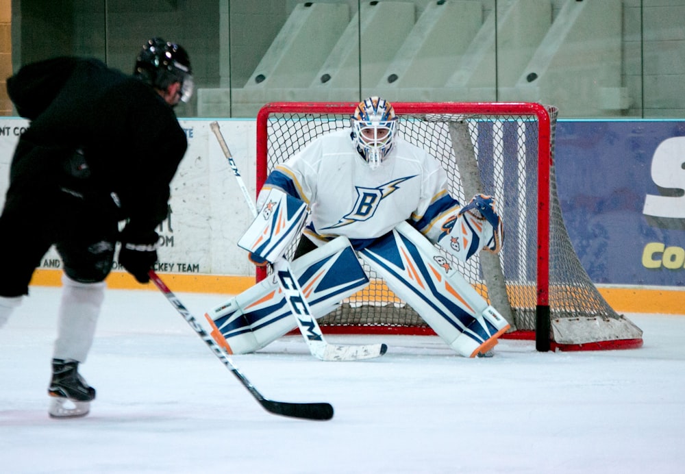 man taking aim for goal on hockey goalie