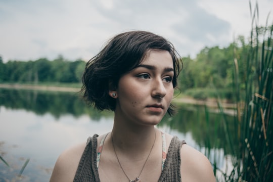 woman in gray tank top with body of water background in Detroit United States