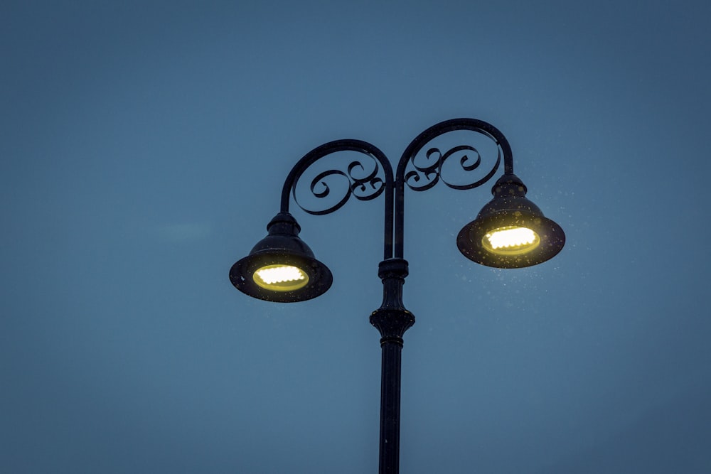black 2-light street lamp turned on during night