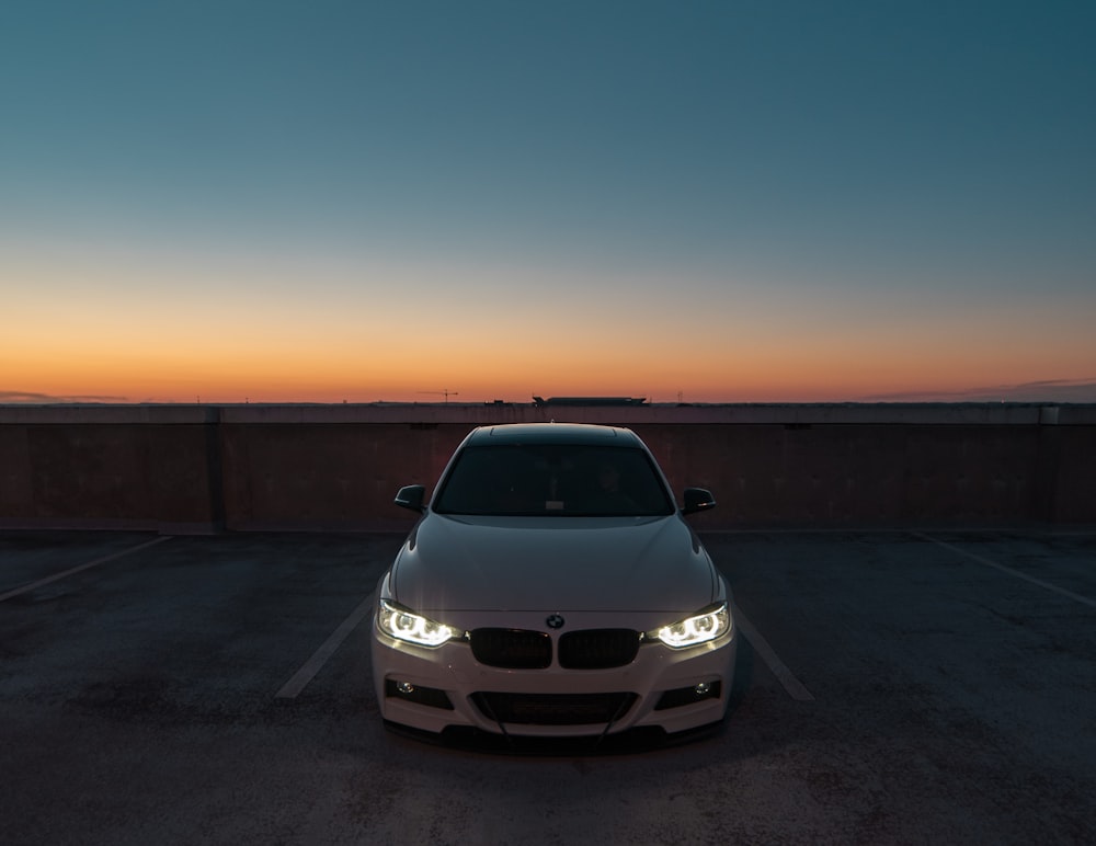 Coche BMW blanco cerca de la pared aparcado