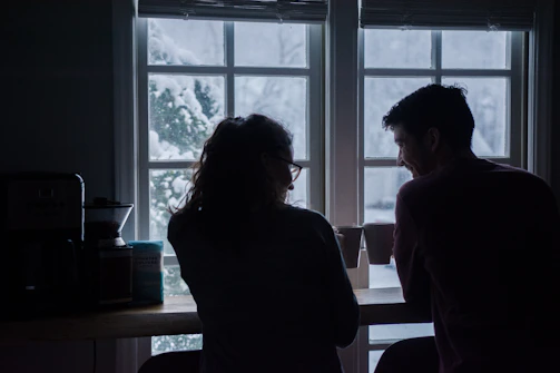 A cozy café setting with a couple sharing a warm smile over coffee.