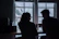 A joyful couple sharing a coffee in a cozy café, smiling warmly at each other.