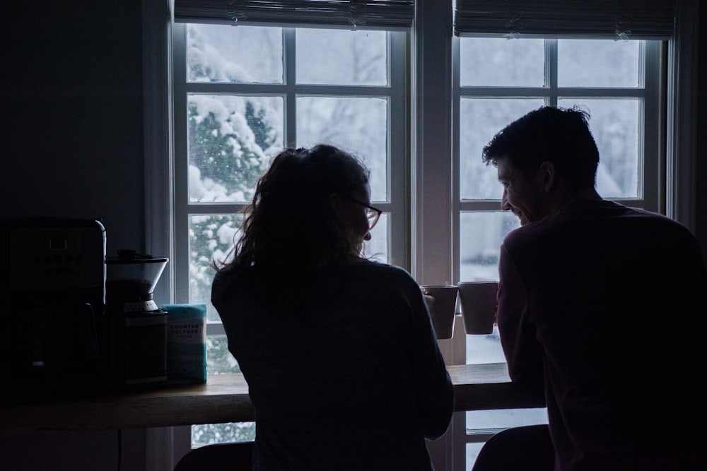 silhouette of man and woman sitting on bar stools