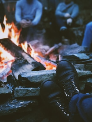 A campfire scene with durable gear and apparel casually arranged nearby.