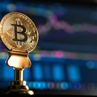 selective focus photo of Bitcoin near monitor