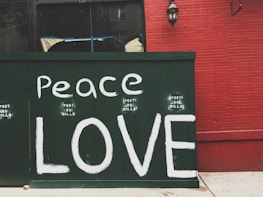 Peace Love painted on green wall