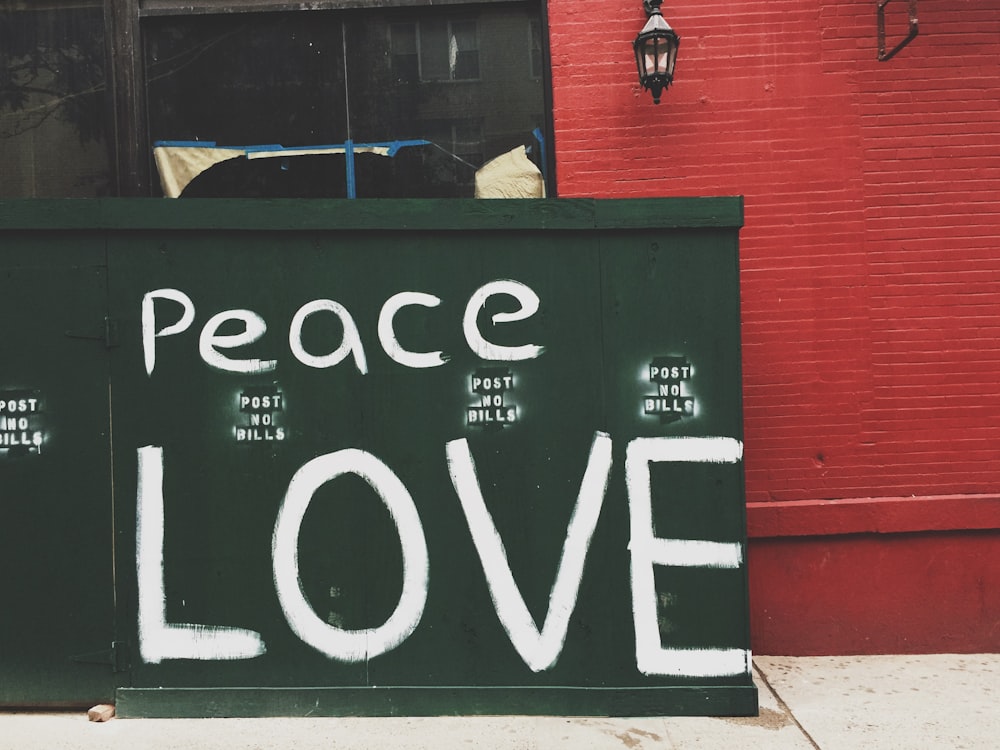 Peace Love painted on green wall