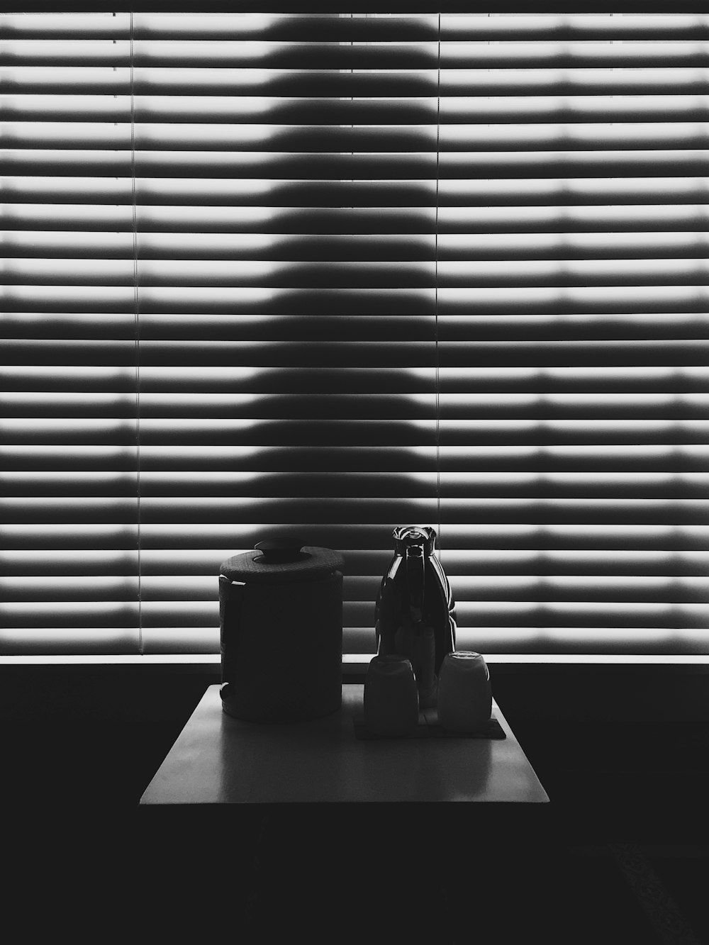Recipiente negro y jarra encima de la mesa