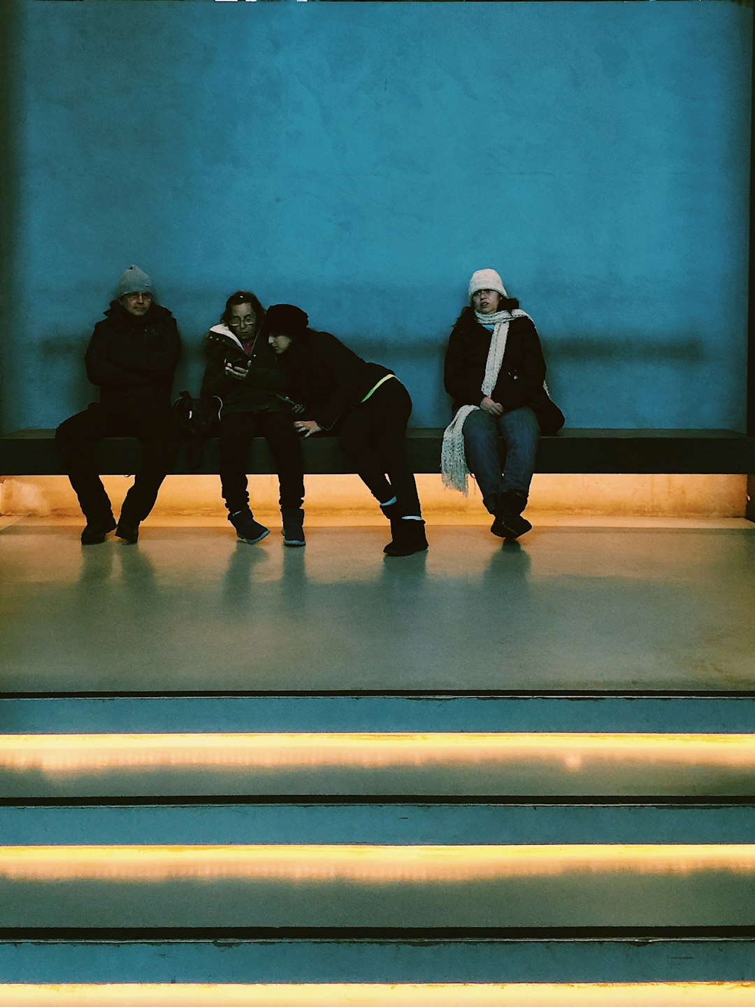 people sits near blue wall