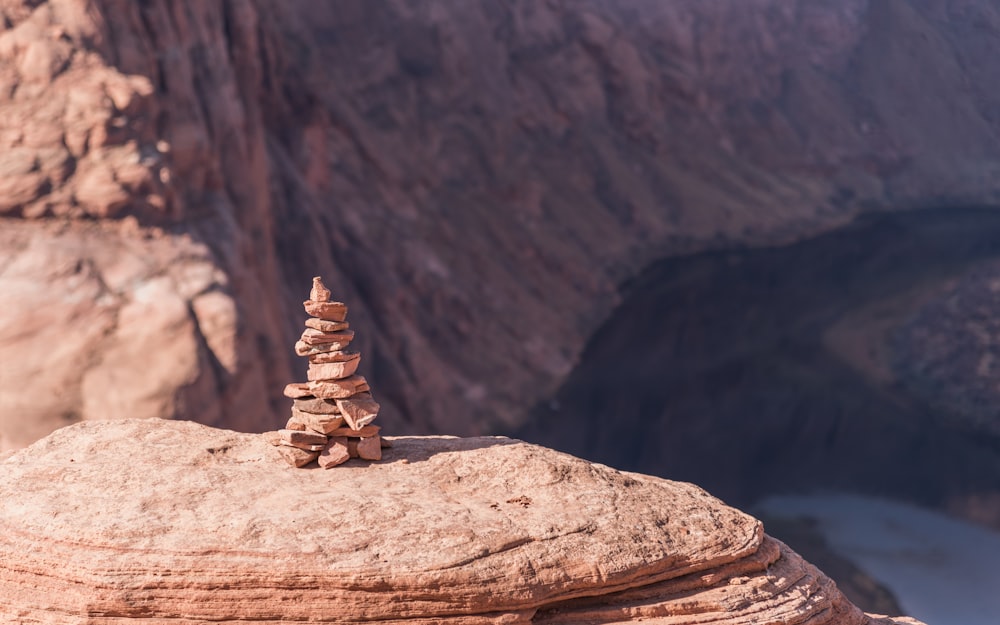photo of stacking stone place on cliff near body of water