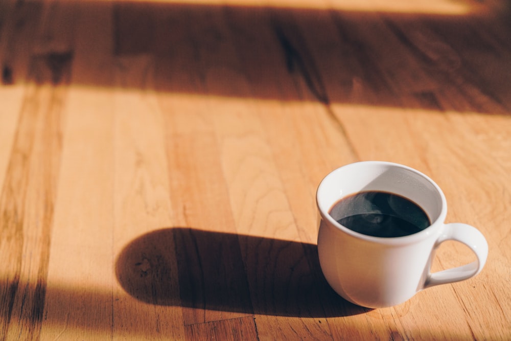 white ceramic mug on brown wooden surface