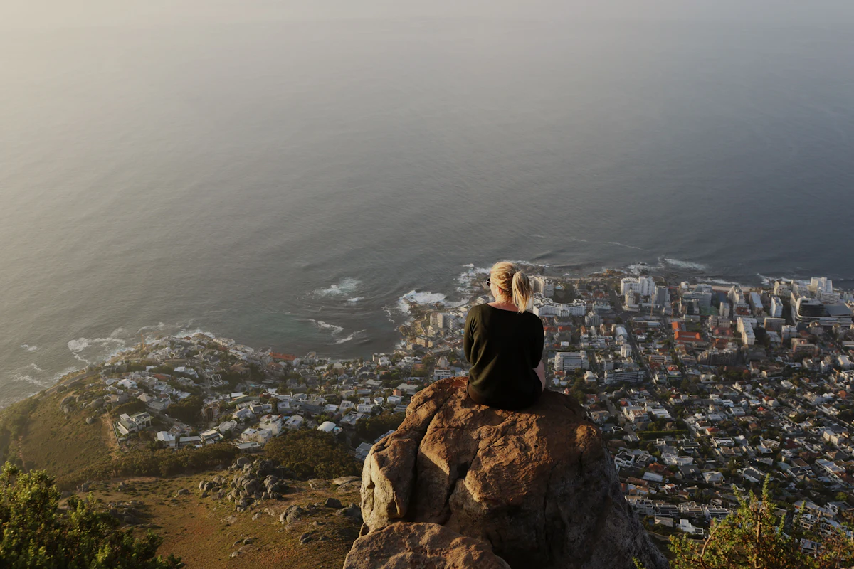 A hiker on Lion’s Head looking over Cape Town at sunset