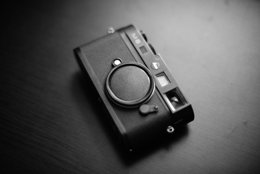 grayscale photo of M8 camera on table