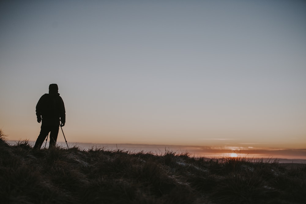 man standing on mountain with sunset