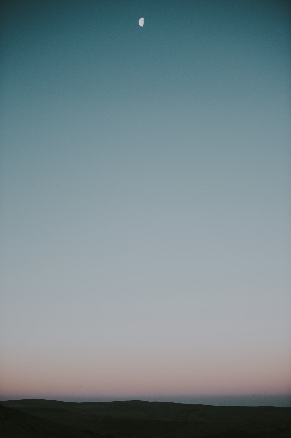 La luna se está poniendo en el cielo sobre el desierto