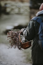 Sophie smiling warmly while holding a basket full of freshly picked wild plants