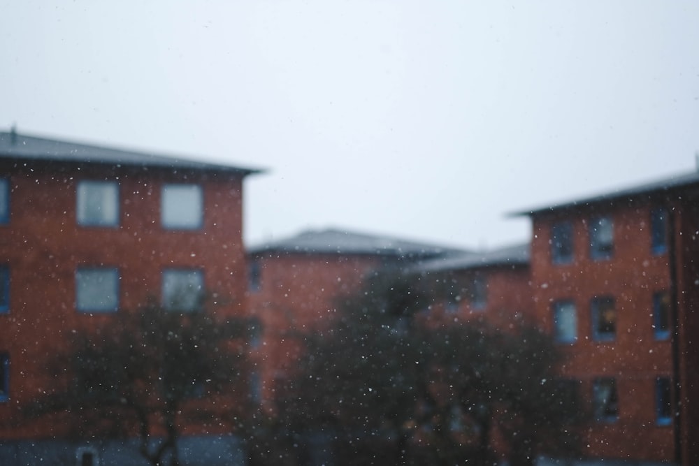 une image floue d’un bâtiment et d’arbres dans la neige