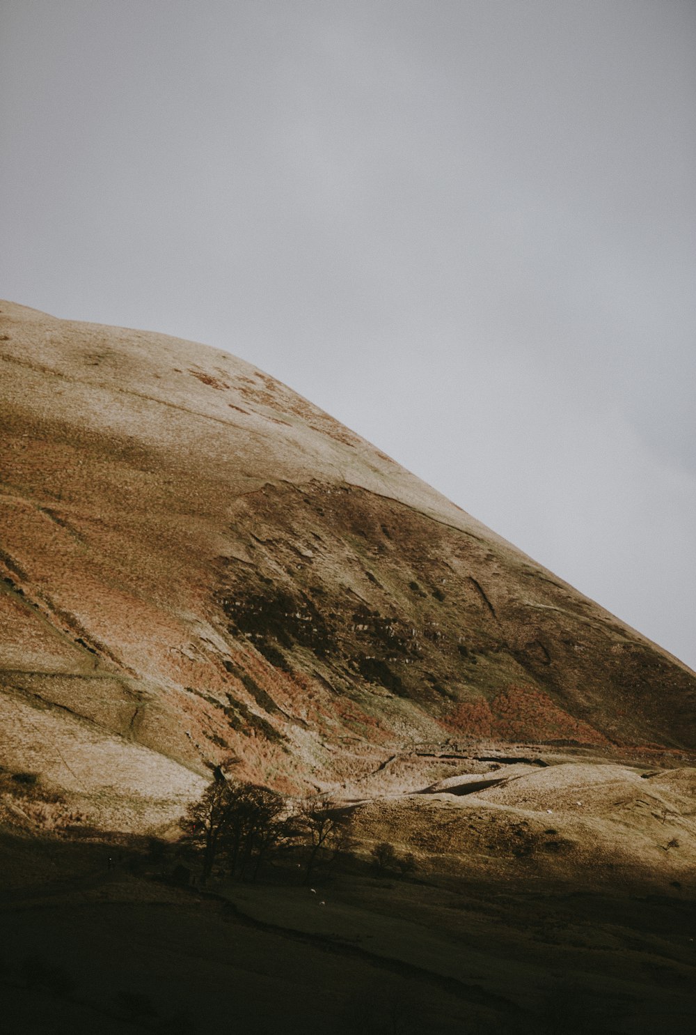 photo of brown mountain under gray clouds