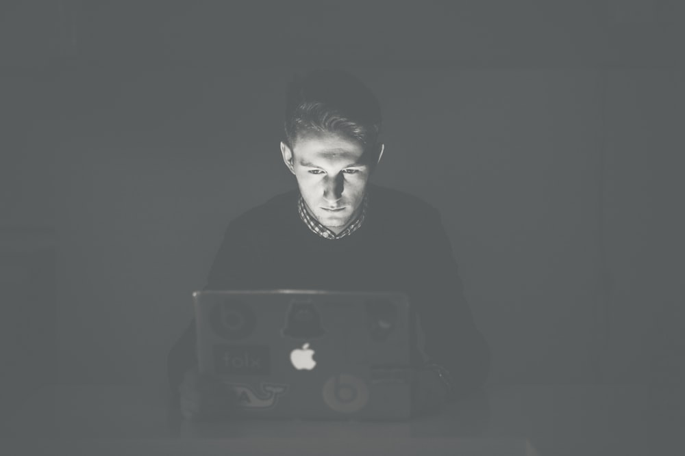 man staring at black MacBook