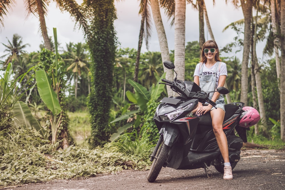 Mujer sonriendo en la parte superior de la moto negra