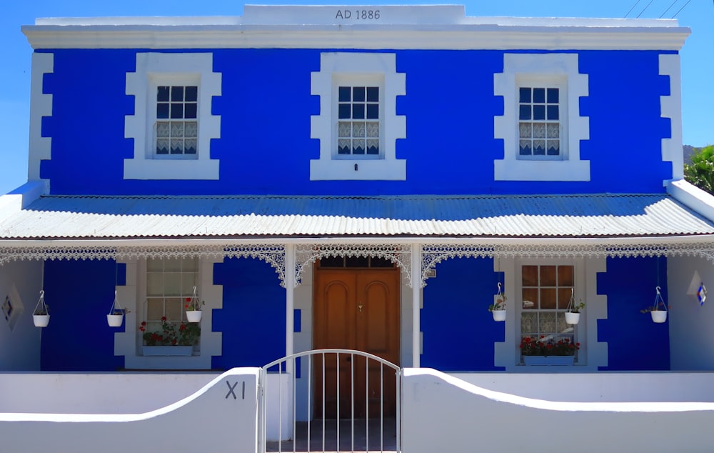 Casa de 2 plantas pintada de blanco y azul